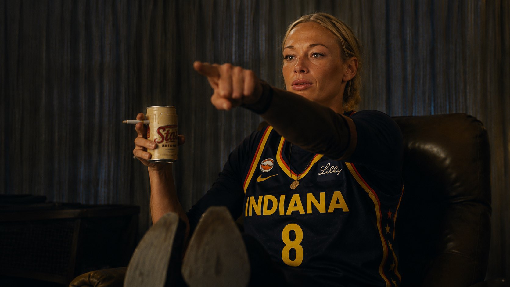 Indiana Fever player pointing with a beer in a recliner