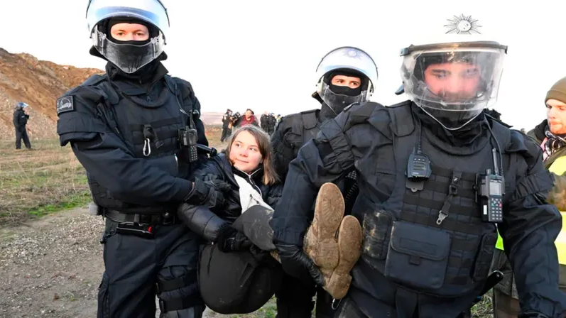 Greta Carried Away meme template - A photo showing Greta Thunberg being carried away by two German police officers during a climate protest. She appears to be s