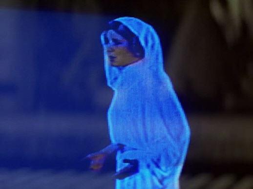 Help Me Obi-Wan meme template - Princess Leia appears as a small, ghostly blue hologram, hands clasped in front of her in a pleading gesture. She wears the i