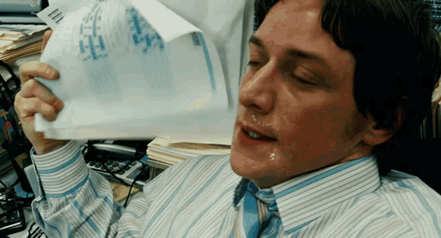 James McAvoy Fanning Himself GIF meme template - An animated GIF of James McAvoy rapidly fanning himself with papers. The repetitive motion creates a sense of escalating over
