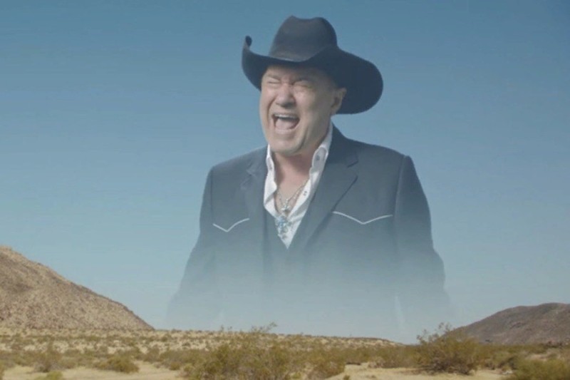 Screaming Cowboy meme template - A man in a black cowboy hat and dark suit appears as a massive, semi-transparent ghost superimposed over a barren desert land
