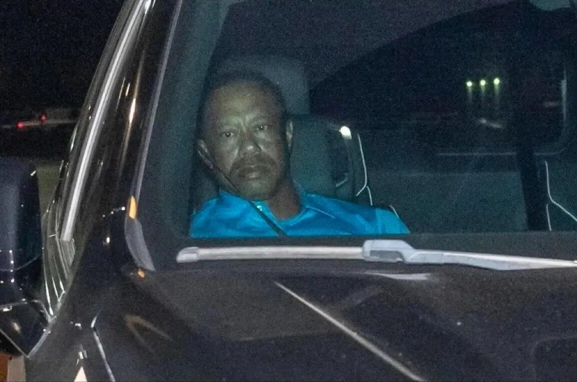 Tiger Woods DUI In Car 2026 meme template - Tiger Woods sits in a car at night, his face lit through the windshield. He wears a blue polo. His expression is the definiti