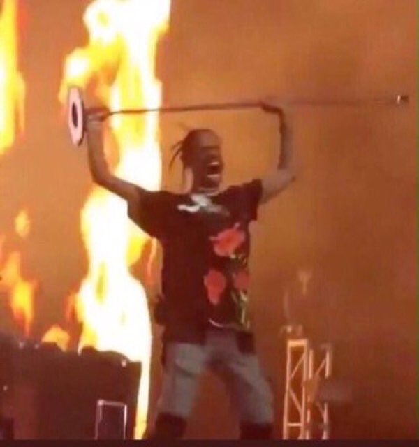 Travis Scott Fire meme template - Travis Scott standing in the foreground with flames or fire visible behind him. His posture and expression communicate absolu